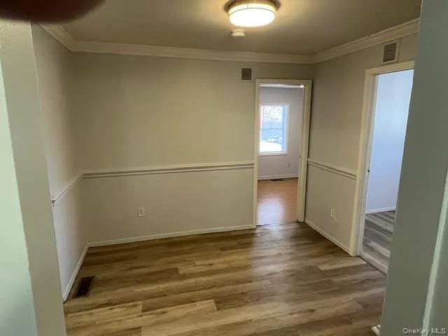 a view of a big room with wooden floor and windows