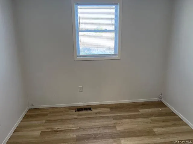 a view of a room with wooden floor and window