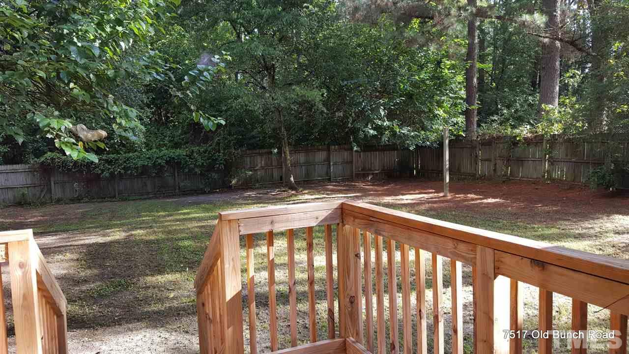 7517 Old Bunch Road Zebulon, NC 27597 - Photo 16 of 25 a view of a backyard with large trees and wooden fence