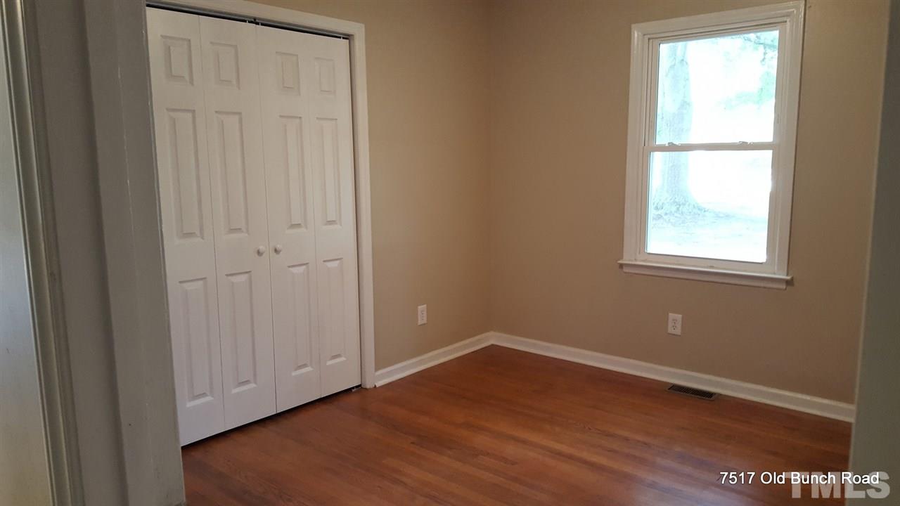 7517 Old Bunch Road Zebulon, NC 27597 - Photo 21 of 25 a view of an empty room with wooden floor and a window