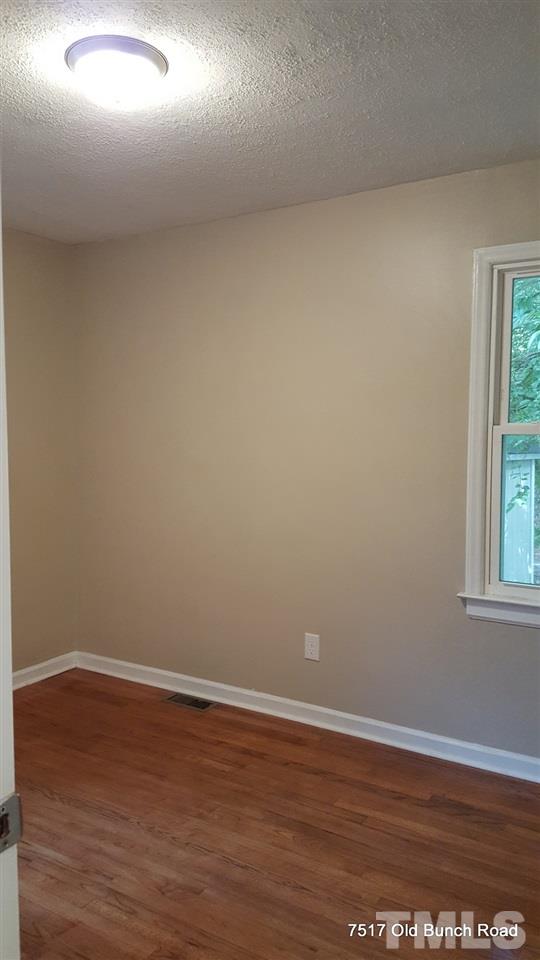 7517 Old Bunch Road Zebulon, NC 27597 - Photo 22 of 25 a view of an empty room with wooden floor and a window