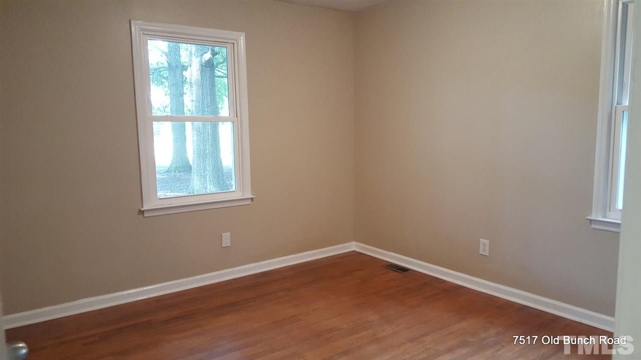 7517 Old Bunch Road Zebulon, NC 27597 - Photo 23 of 25 an empty room with wooden floor and windows