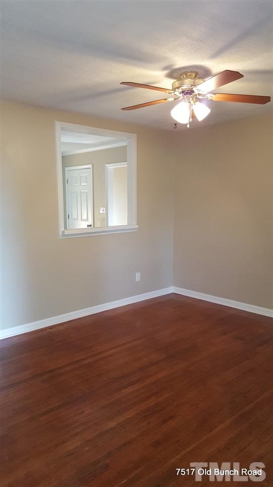 7517 Old Bunch Road Zebulon, NC 27597 - Photo 4 of 25 a view of an empty room with wooden floor and a window