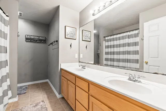 a bathroom with a granite countertop toilet and a shower