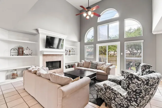 a living room with furniture a fireplace and a large window