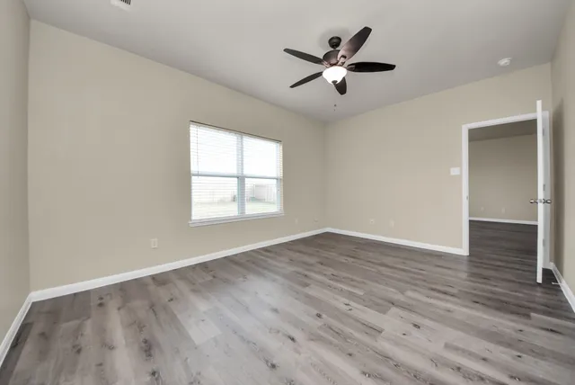 a view of a hallway with wooden floor and cabinet