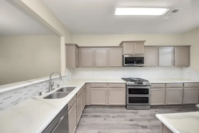 a kitchen with stainless steel appliances granite countertop a sink stove and refrigerator