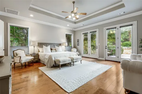 a bed sitting in a spacious bedroom next to a window