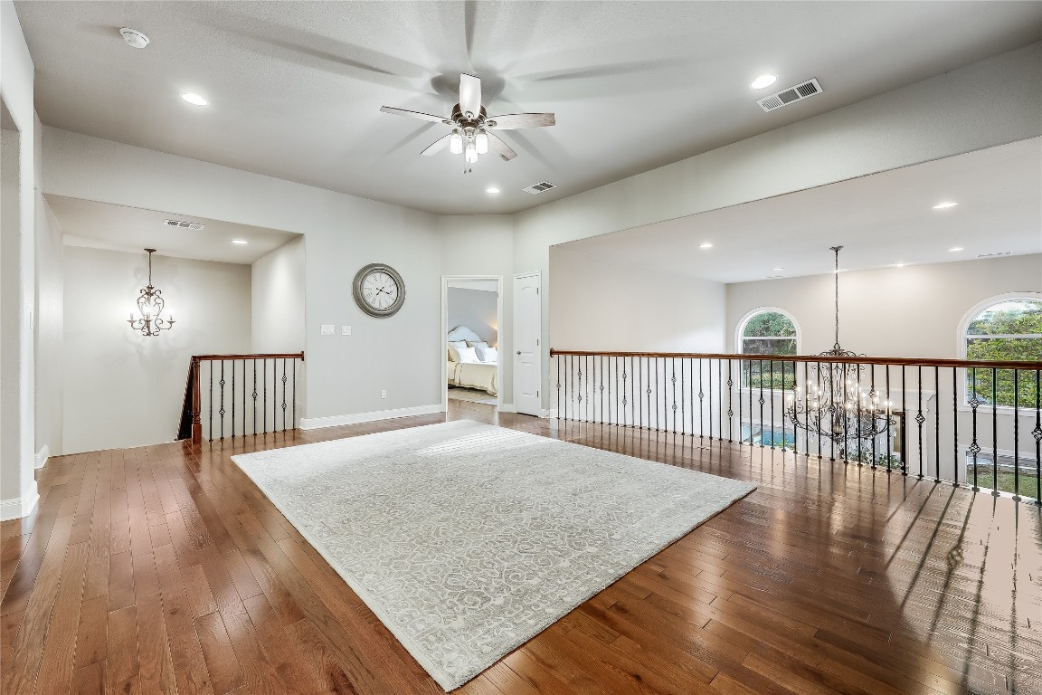 2116 Demona Drive Austin, TX 78733 - Photo 20 of 40 a view of a hallway with wooden floor and chandelier
