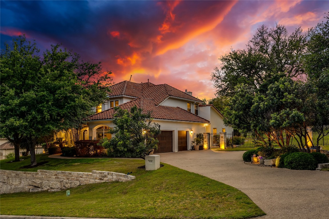 2116 Demona Drive Austin, TX 78733 - Photo 32 of 40 a front view of a house with a garden and a tree