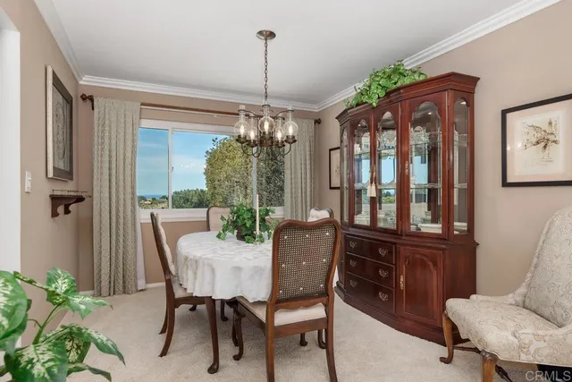 a view of a dining room with furniture a chandelier and wooden floor