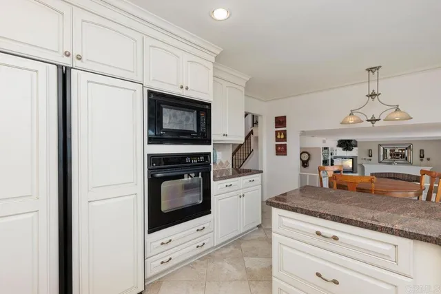a kitchen with stainless steel appliances granite countertop a kitchen island a stove a table and chairs in it