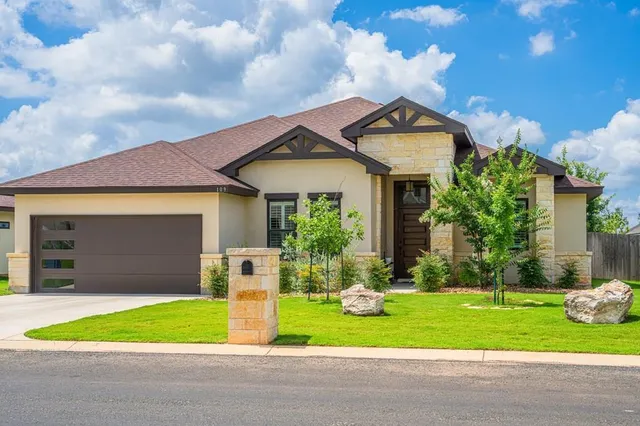 a front view of a house with a yard and garage