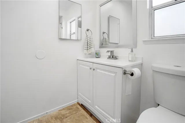 a bathroom with a sink and mirror with toilet