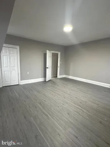 a view of an empty room with wooden floor and windows