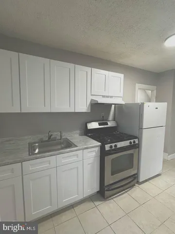a kitchen with stainless steel appliances granite countertop a stove a sink and a white cabinets