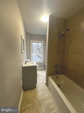a bathroom with a tub a sink and mirror