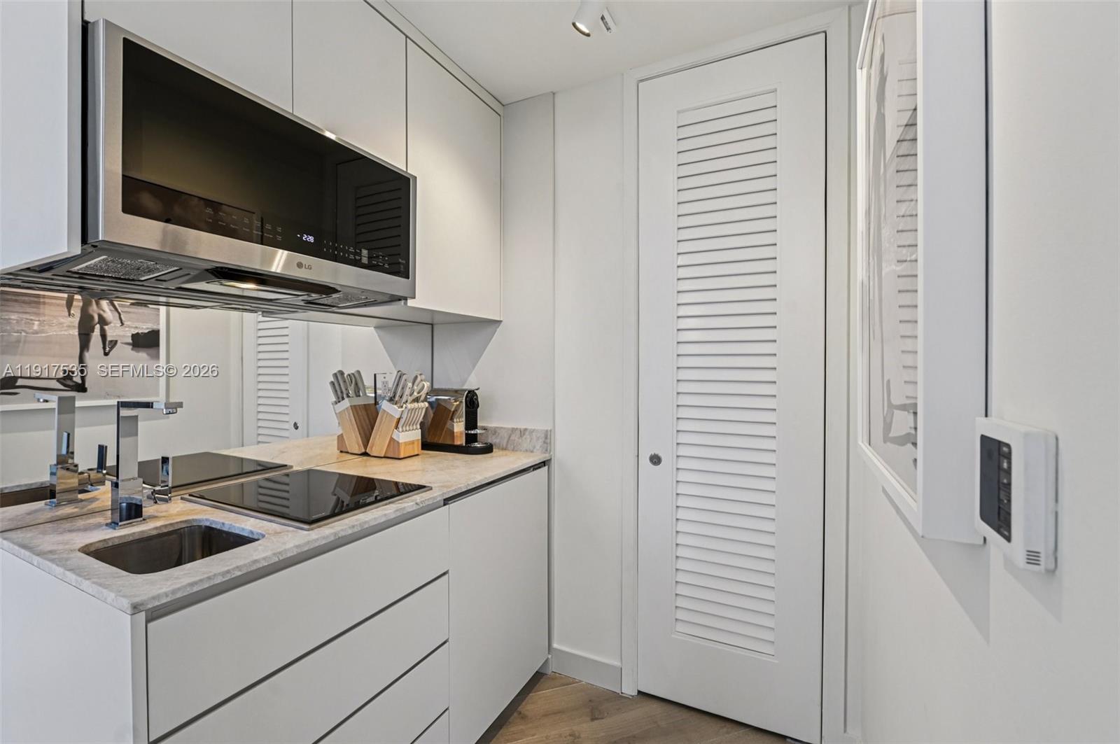 2201 Collins Avenue, Unit 401 Miami Beach, FL 33139 - Photo 12 of 20 a kitchen with a sink and a stove top oven