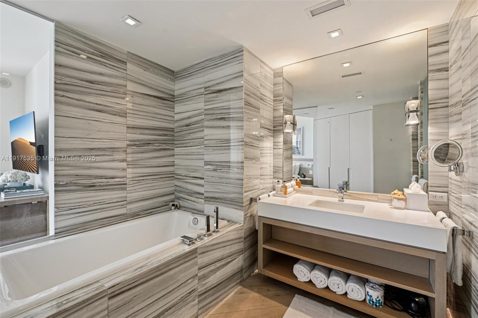 2201 Collins Avenue, Unit 401 Miami Beach, FL 33139 - Photo 17 of 22 a bathroom with a sink and a bathtub