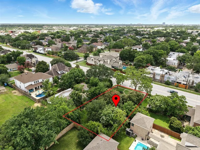 an aerial view of residential houses with outdoor space and trees