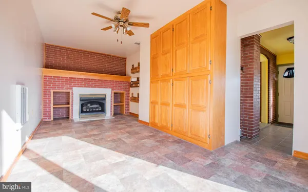 a view of empty room with fireplace and fan