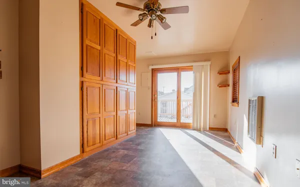 a view of a hallway with a chandelier fan and windows