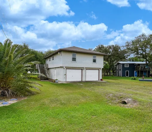 a view of a house with a big yard and a large tree