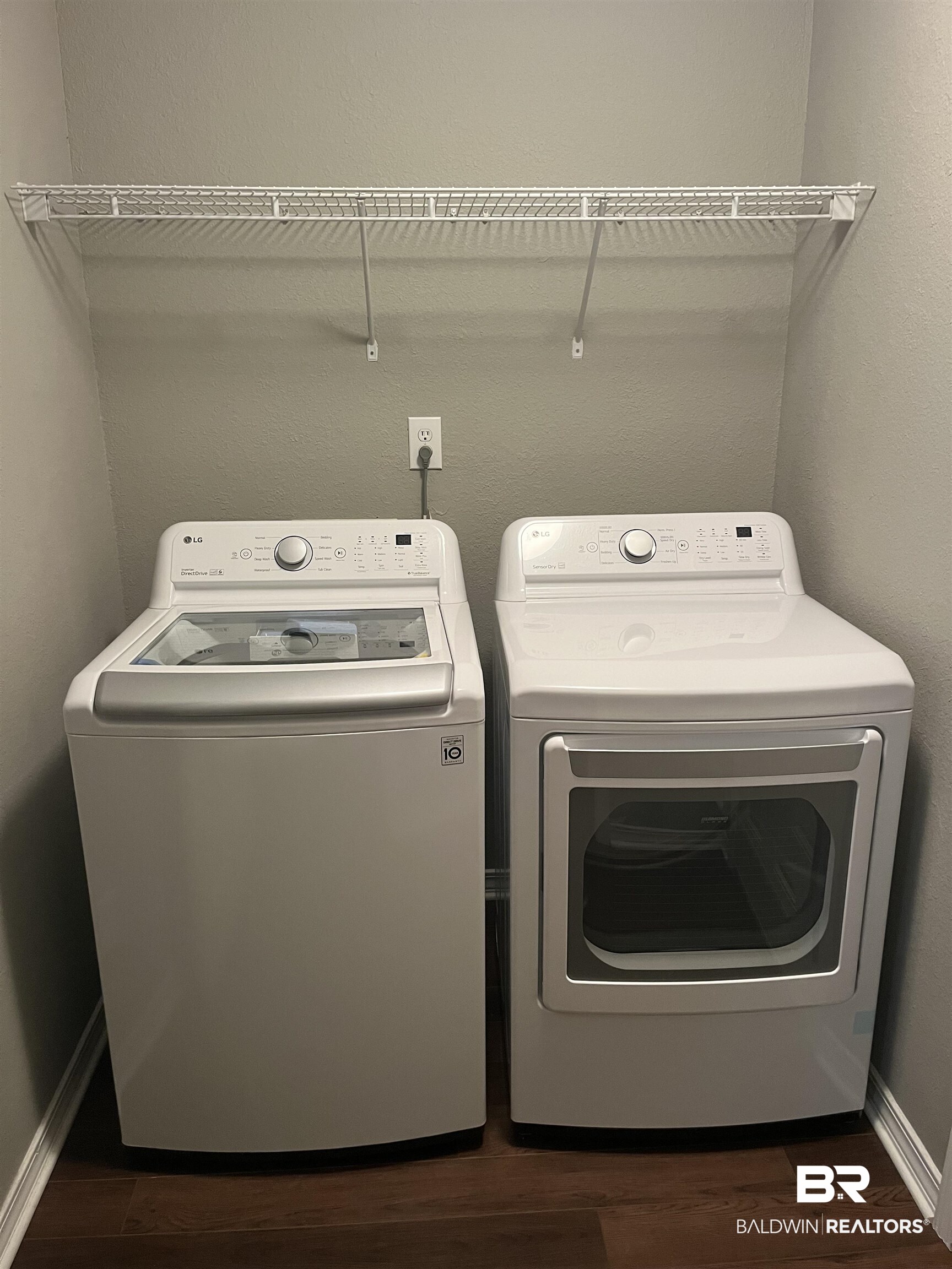 309 Cluster Street Foley, AL 36535 - Photo 25 of 38 Dedicated laundry area featuring a washer and dryer set, wood-finish flooring, light gray walls, and a white wire shelf