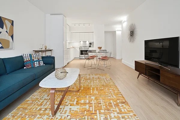 160 West 24th Street, Unit 14K Manhattan, NY 10011 - Photo 4 of 11 a living room with furniture and a flat screen tv