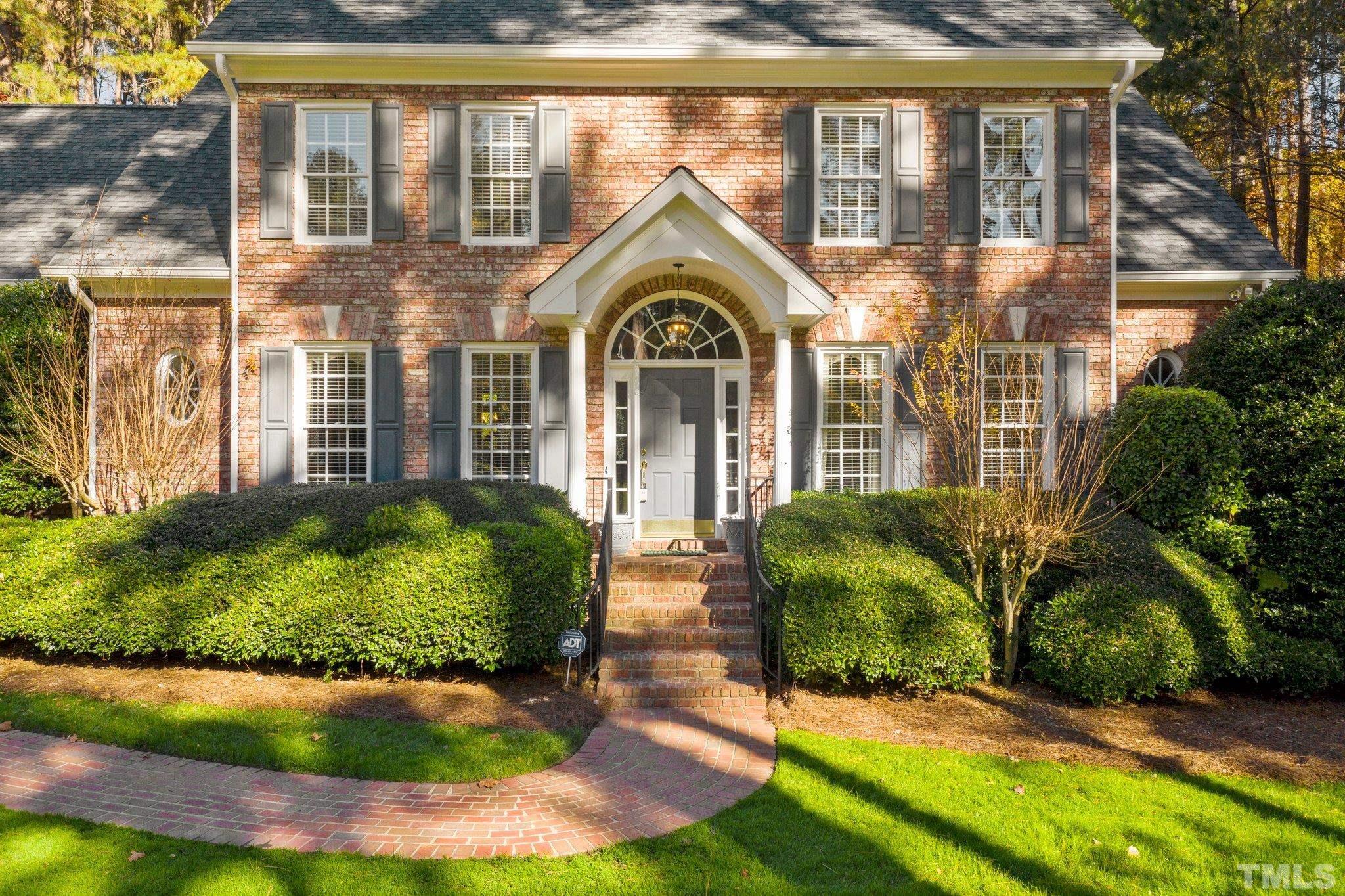 1024 White Crane Way Raleigh, NC 27615 - Photo 4 of 30 a view of a brick house with a large windows and a yard with plants and large tree