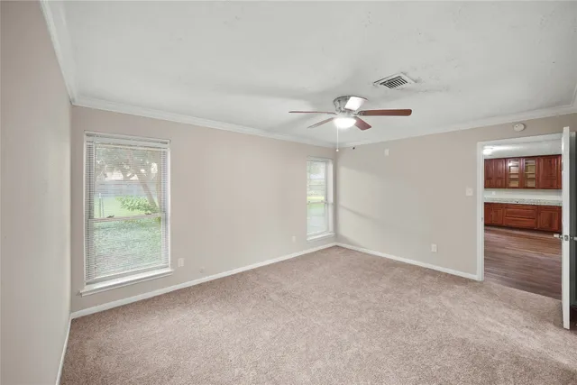 an empty room with fan and windows
