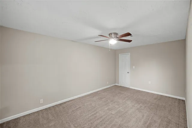 a view of an empty room with a ceiling fan