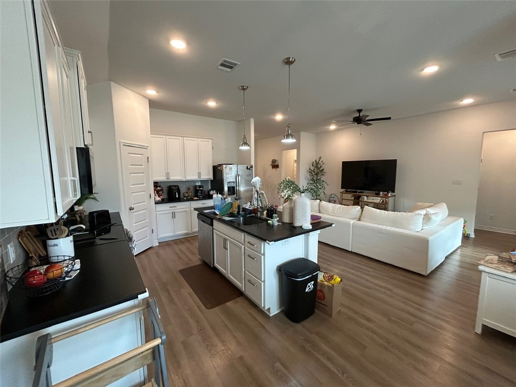 3169 Normandy Way Bryan, TX 77808 - Photo 23 of 24 a large living room with stainless steel appliances kitchen island granite countertop a couch and a view of living room