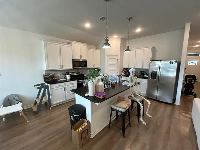 a large living room with stainless steel appliances kitchen island granite countertop a couch and a view of living room