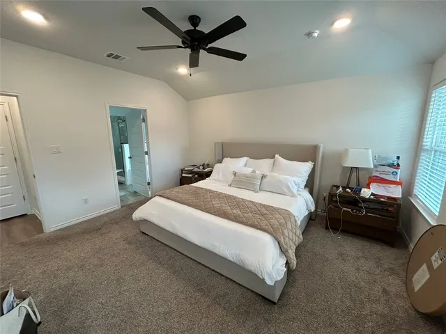 a bedroom with a bed and a ceiling fan