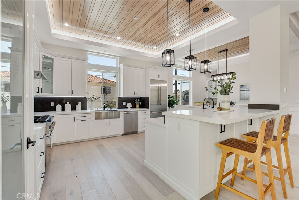 1725 Clark Lane Redondo Beach, CA 90278 - Photo 12 of 47 a large white kitchen with living room a stove and white cabinets with wooden floor