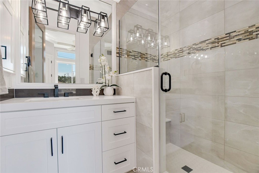 1725 Clark Lane Redondo Beach, CA 90278 - Photo 21 of 47 a bathroom with a double vanity sink a mirror a glass door a shower and vanity