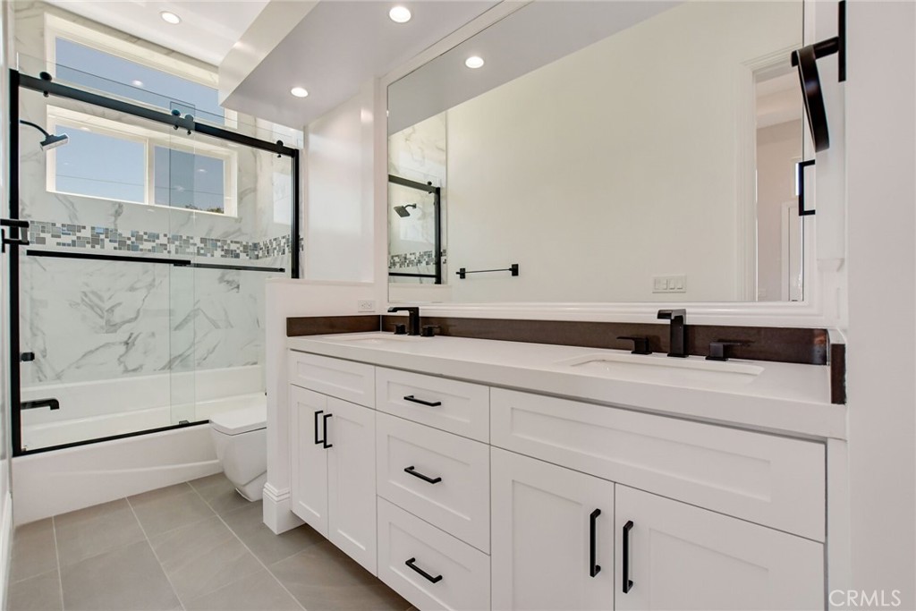 1725 Clark Lane Redondo Beach, CA 90278 - Photo 38 of 47 a bathroom with a double vanity sink a mirror and a bathtub