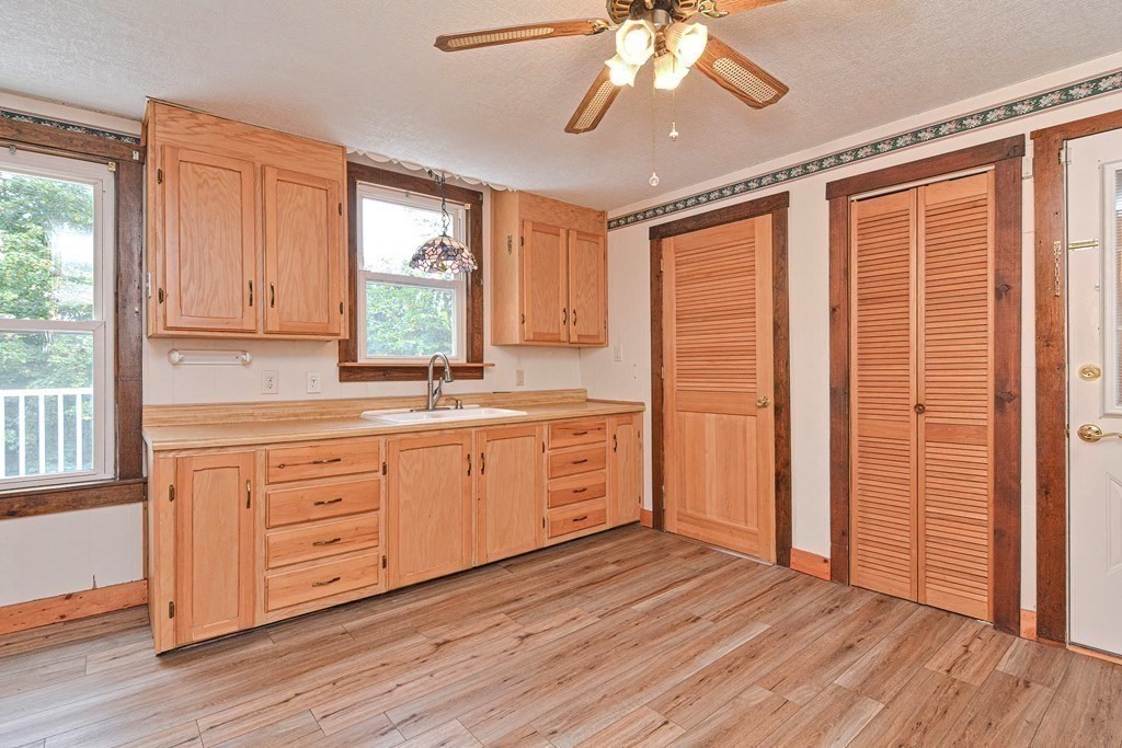 775 3rd Avenue Woonsocket, RI 02895 - Photo 14 of 42 a kitchen with wooden floors and white cabinets