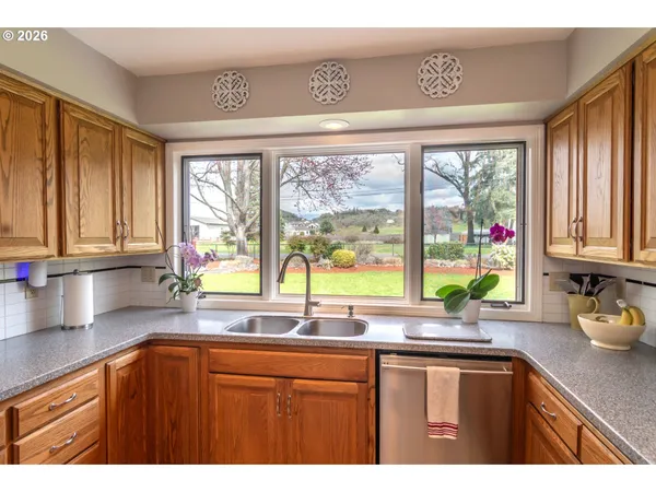 a kitchen with large windows sink and cabinets