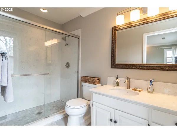 a bathroom with a sink a toilet and shower