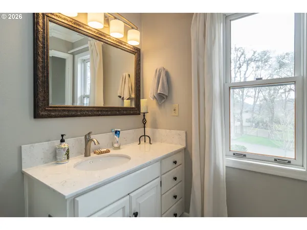 a bathroom with a sink mirror and a window