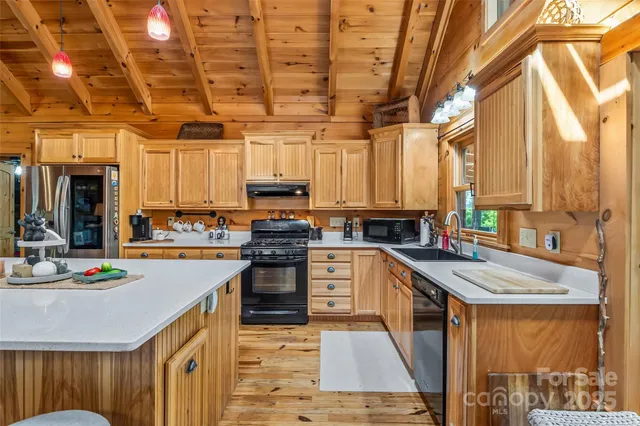 a kitchen with stainless steel appliances granite countertop a sink a stove and cabinets