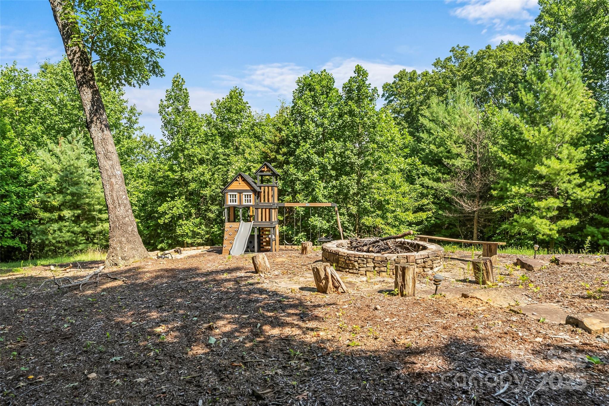 279 Outback Trail Nebo, NC 28761 - Photo 41 of 45 a view of a backyard with table and chairs potted plants and large tree