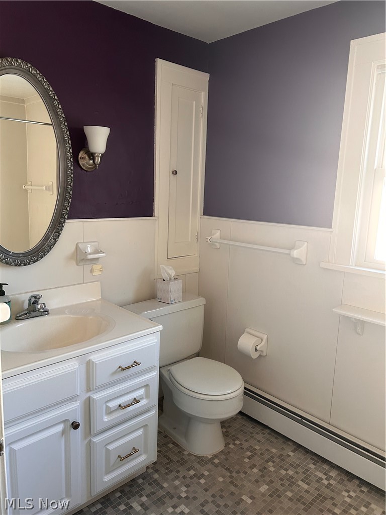 1001 Englewood Road Cleveland Heights, OH 44121 - Photo 13 of 28 Bathroom with a baseboard heating unit, vanity, wainscoting, and dark tile patterned flooring