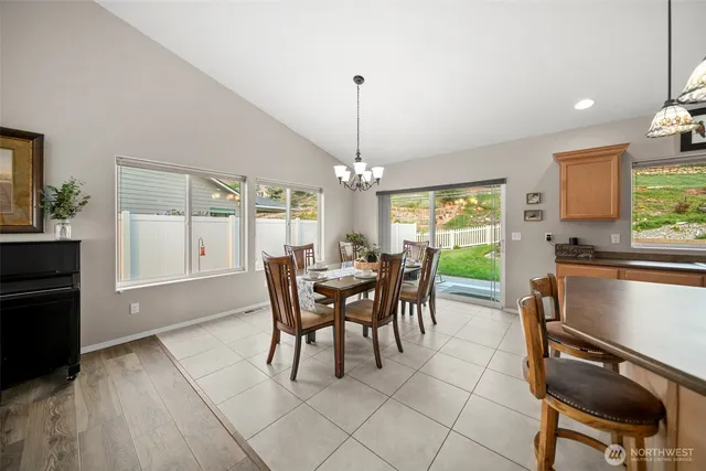 a dining room with furniture a chandelier and wooden floor