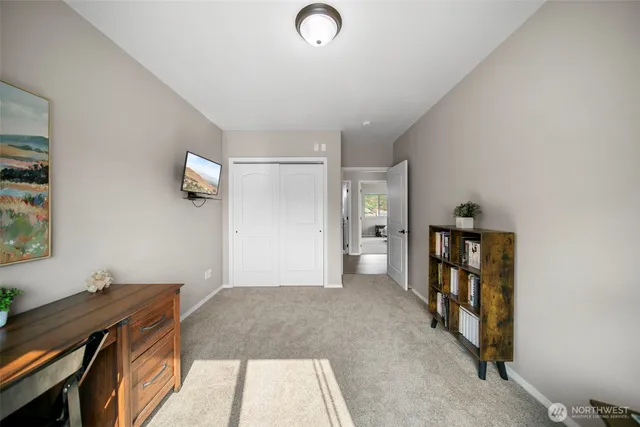 a view of a livingroom with wooden floor and a workspace