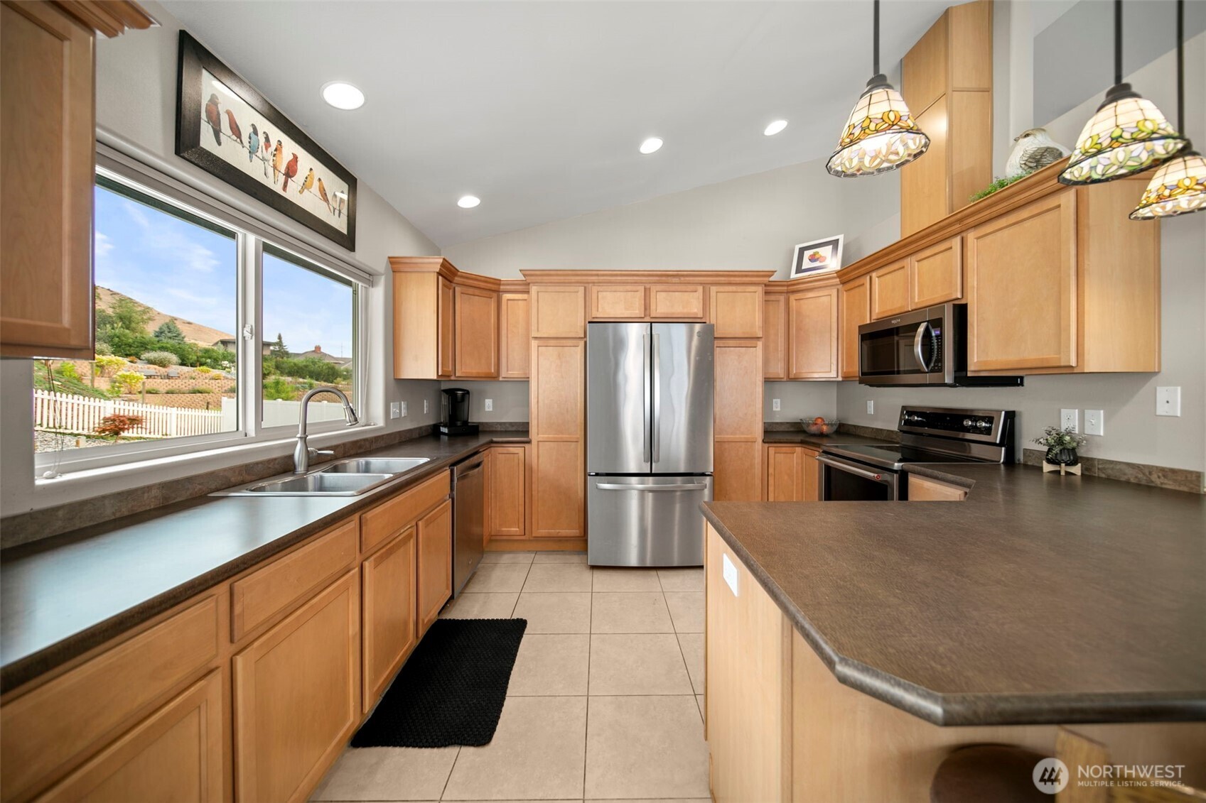 2012 Linville Drive Wenatchee, WA 98801 - Photo 6 of 40 a kitchen with stainless steel appliances granite countertop a sink a stove top oven a refrigerator cabinets and wooden floor