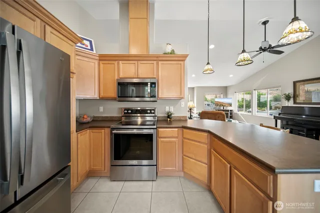 a kitchen with stainless steel appliances granite countertop a sink a stove and a refrigerator
