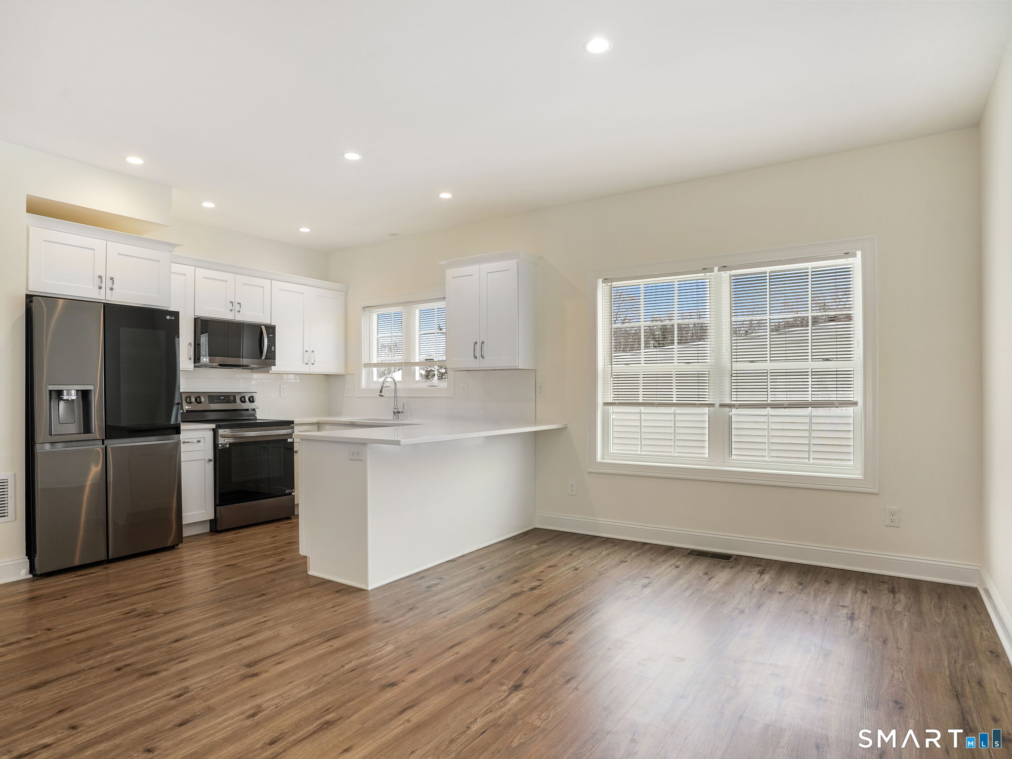 6 Beacon Square, Unit 7 Fairfield, CT 06825 - Photo 15 of 33 a large kitchen with a center island stainless steel appliances and a window